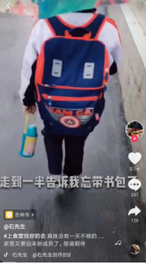 儿子背着巨大的书包在前