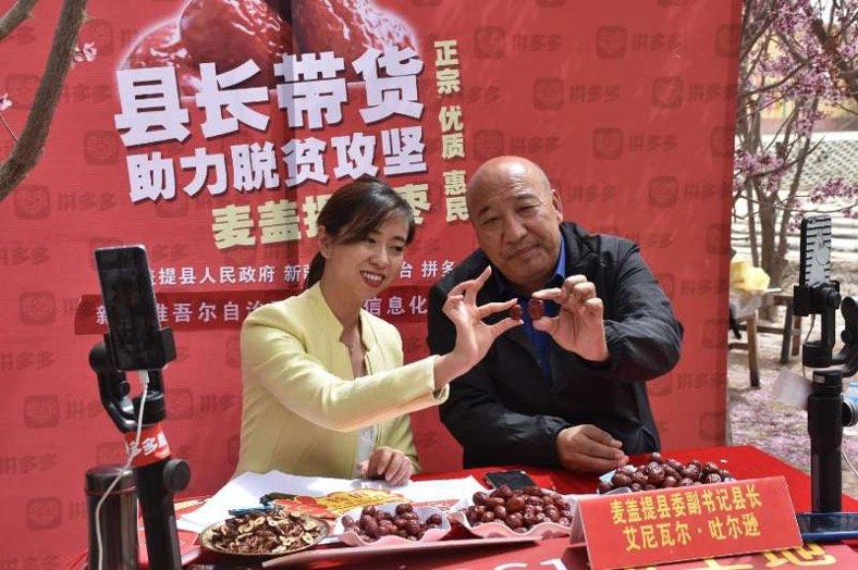 县长艾尼瓦尔·吐尔逊和主持人正在为网