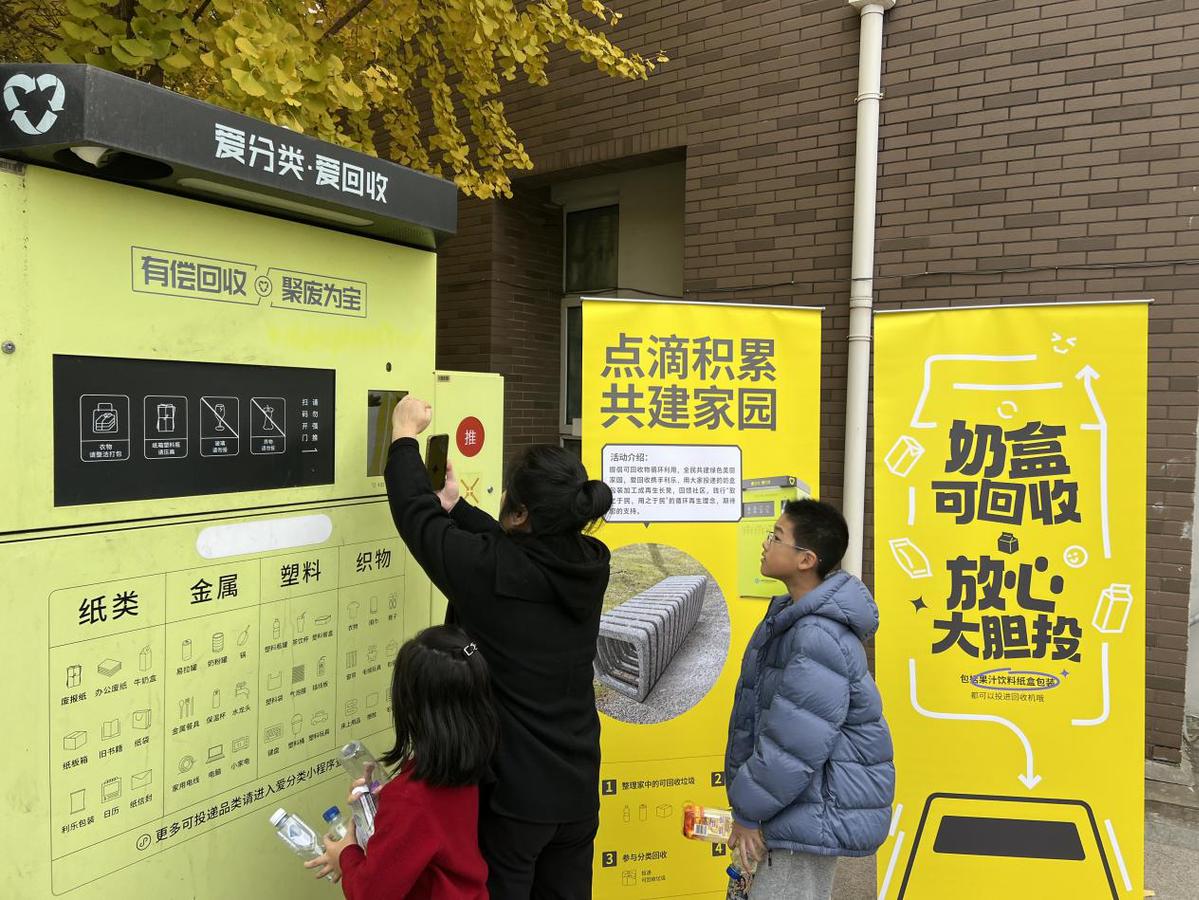 居委书记陪居民来到回收箱前